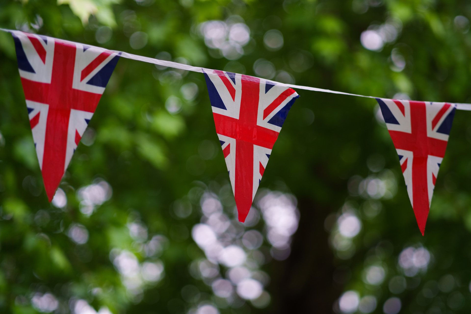 bunting of 3 England flags with trees in the background
