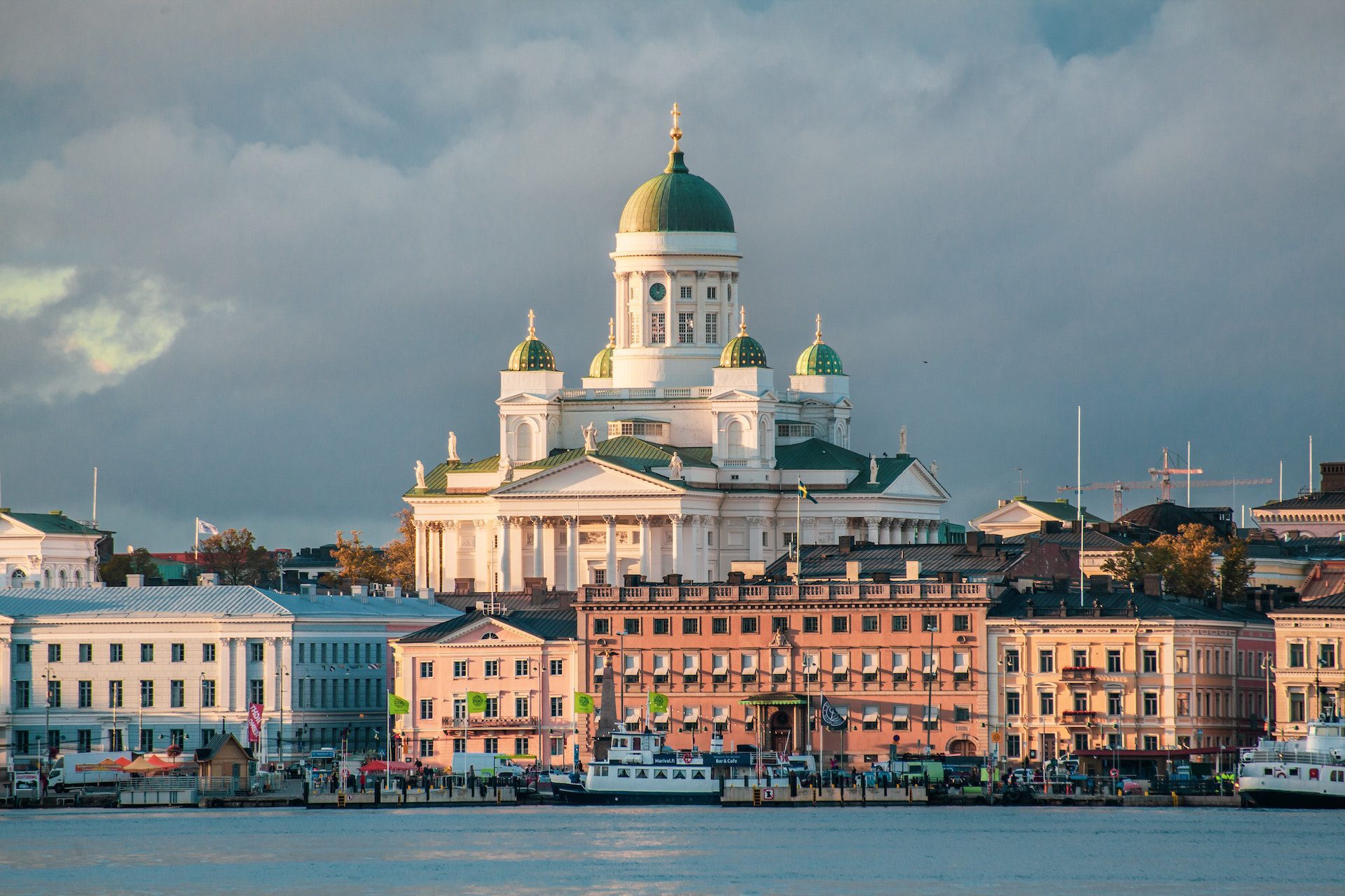 cathedral with buildings in front of a body of water