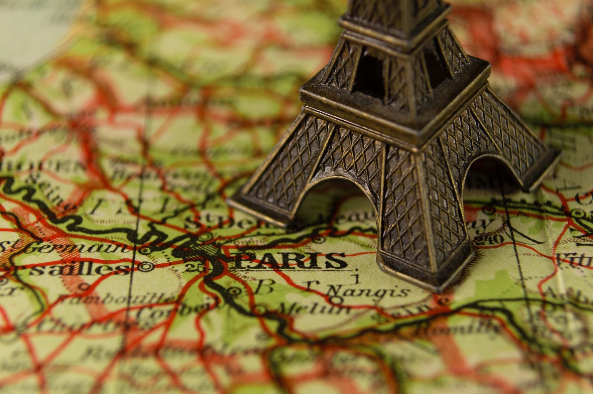 close up of a statue of the Eiffel tower on a map of Paris