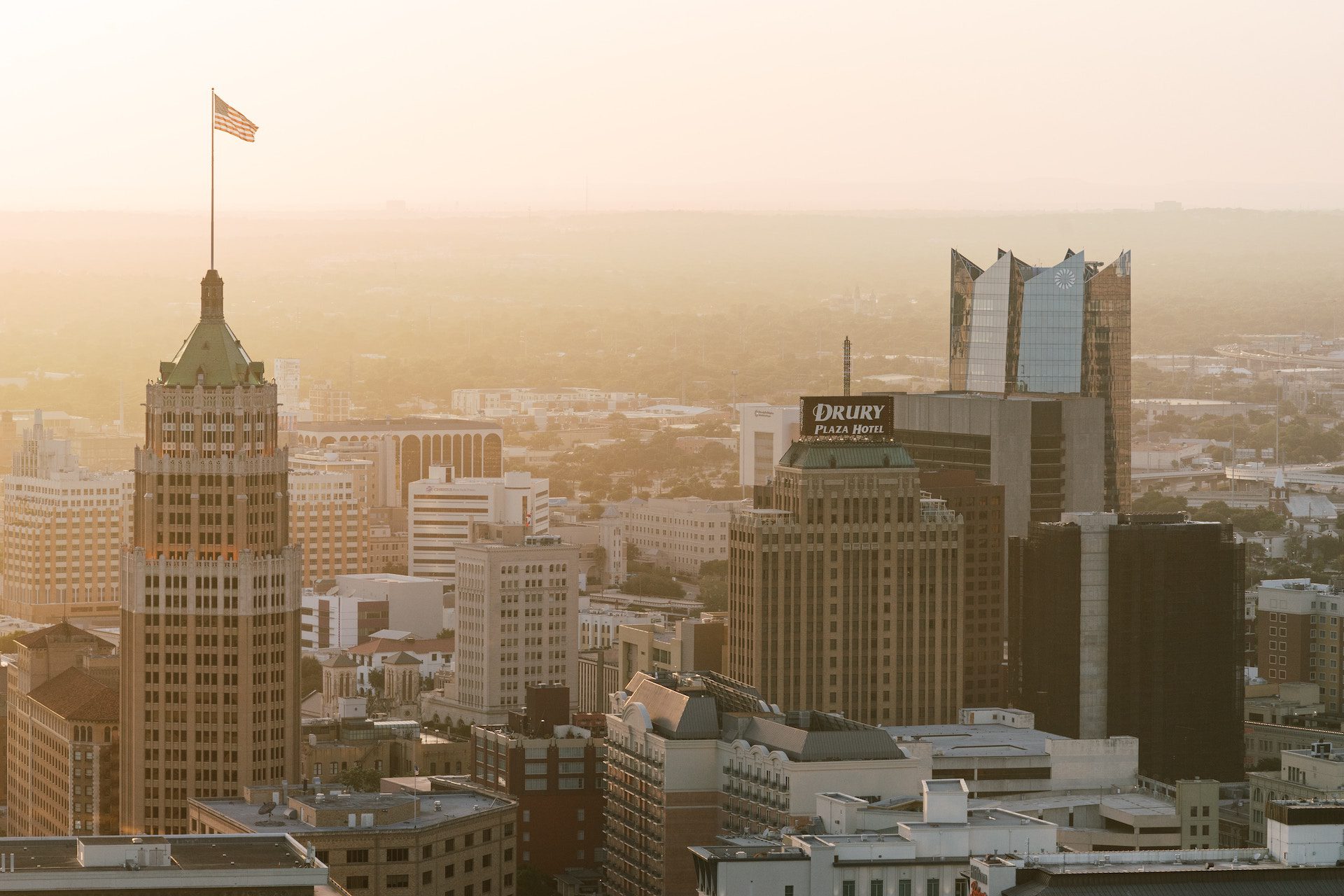 shot of a city with skyscrapers and the United States flag on top of a building