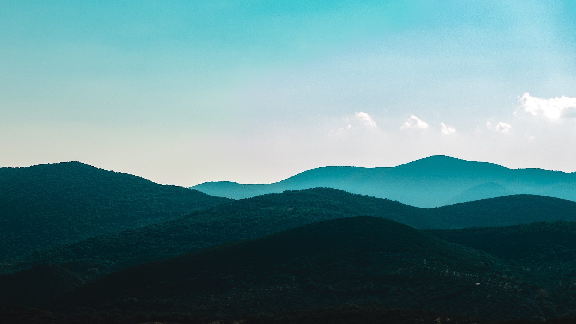 mountains and hills with blue sky in the background