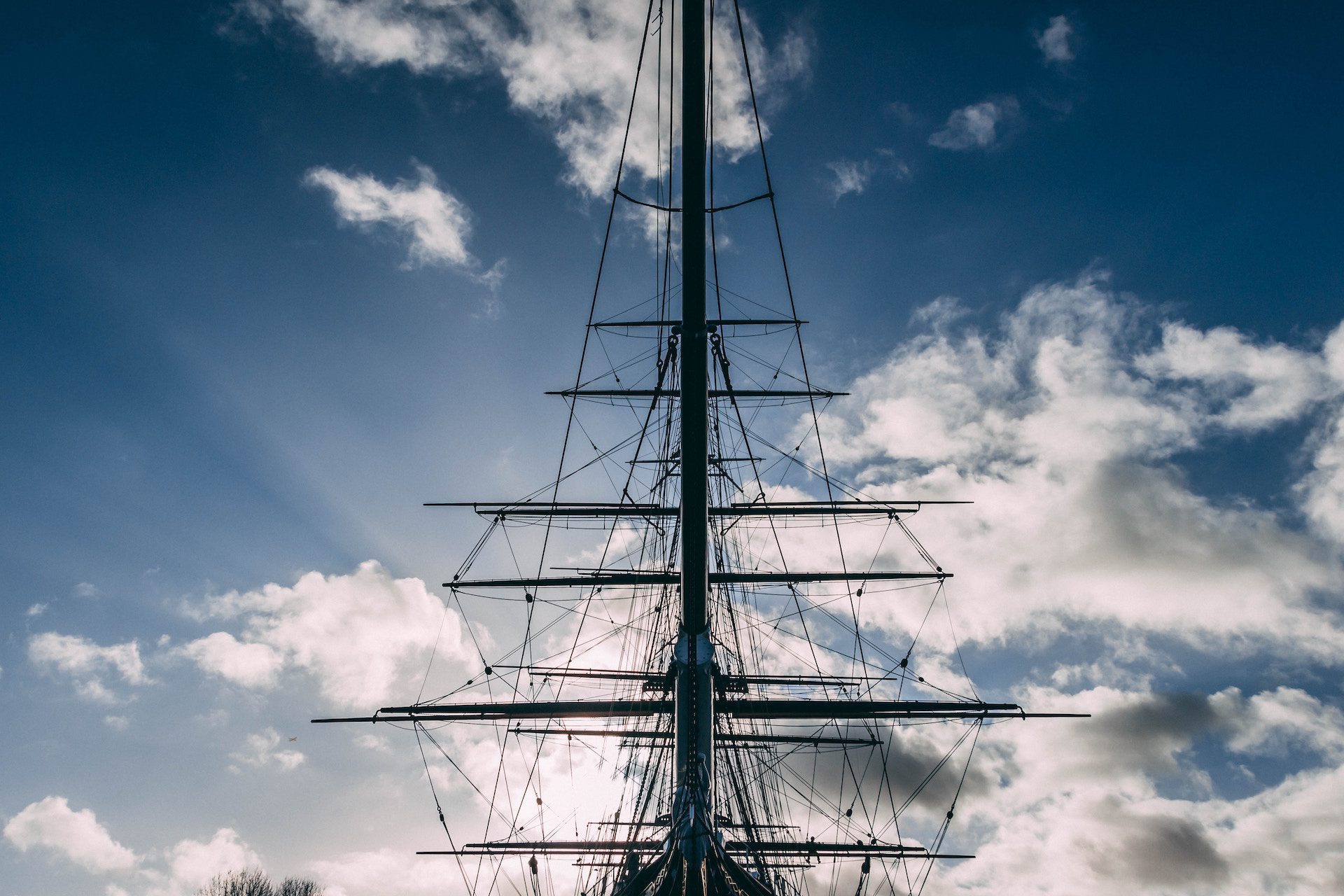 head of a ship with the sky and clouds in the background