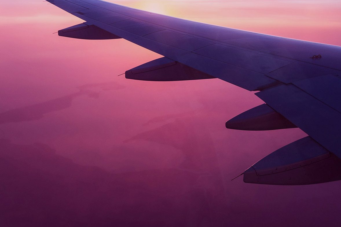 wing of an airplane with a sunset sky