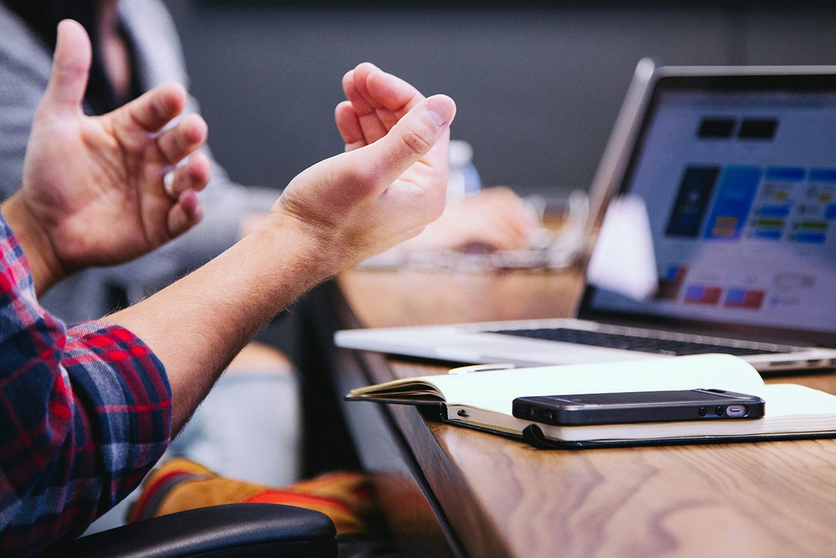 persons hands with laptop in the background